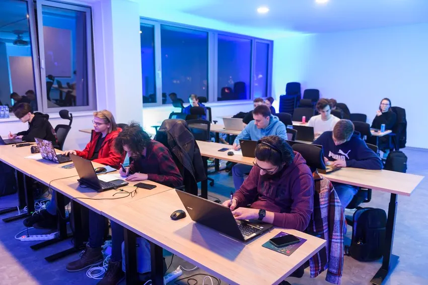 Účastníci workshopu pracujú na notebookoch na Night of Chances 2024